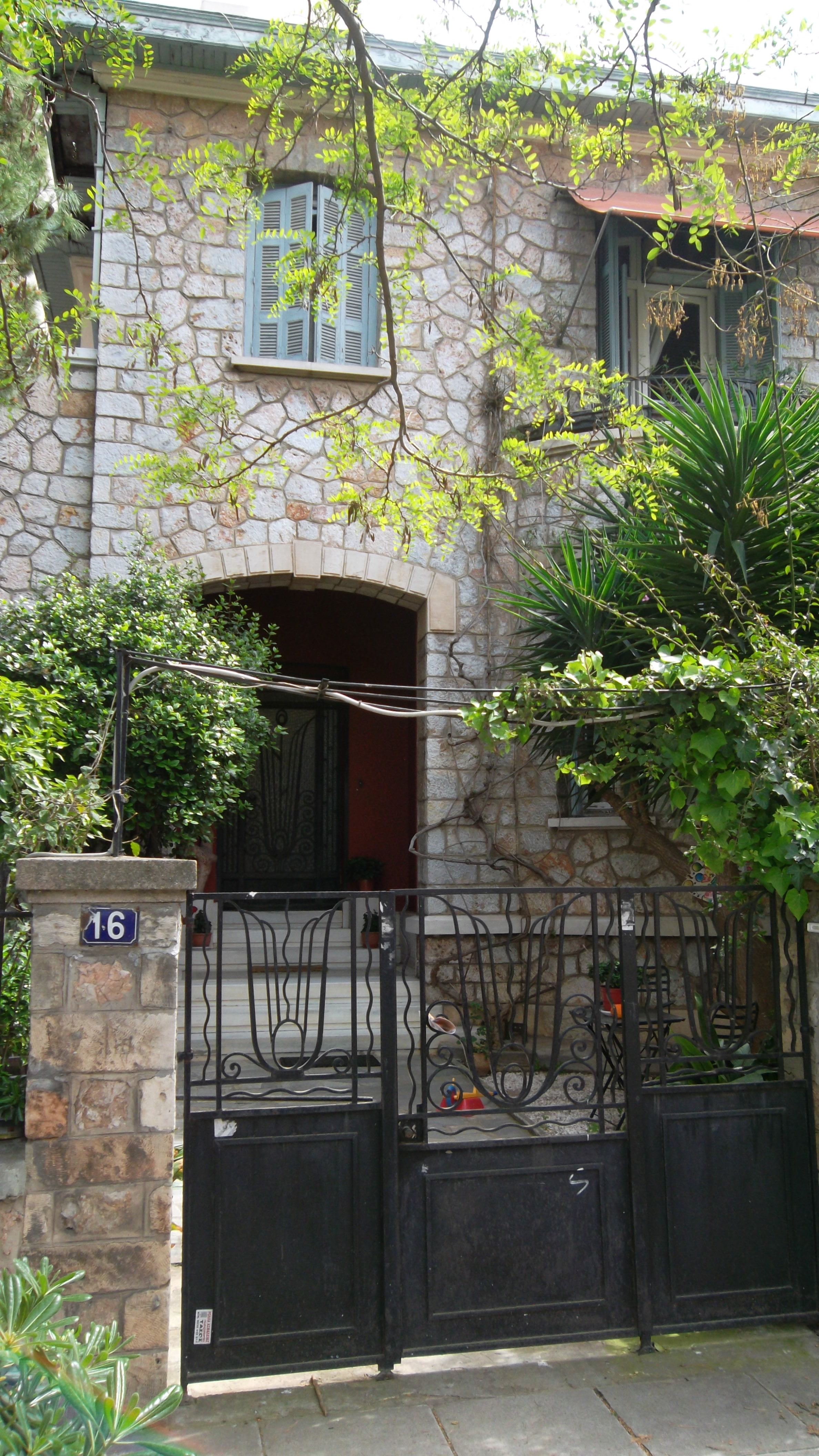 Part of the facade with the front yard door and the entrance